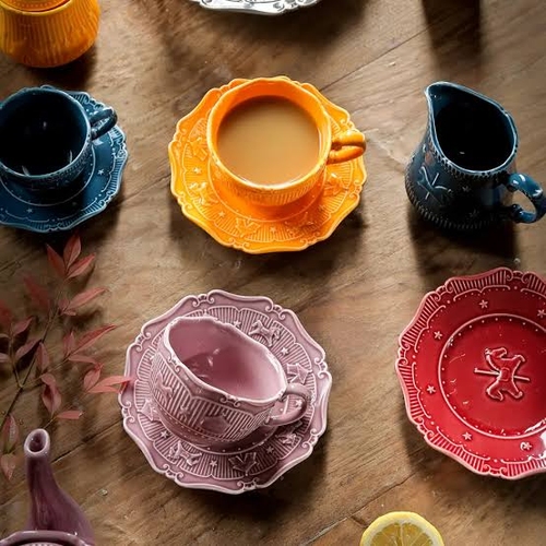 Tasses et soucoupes colorées disposées sur une table en bois